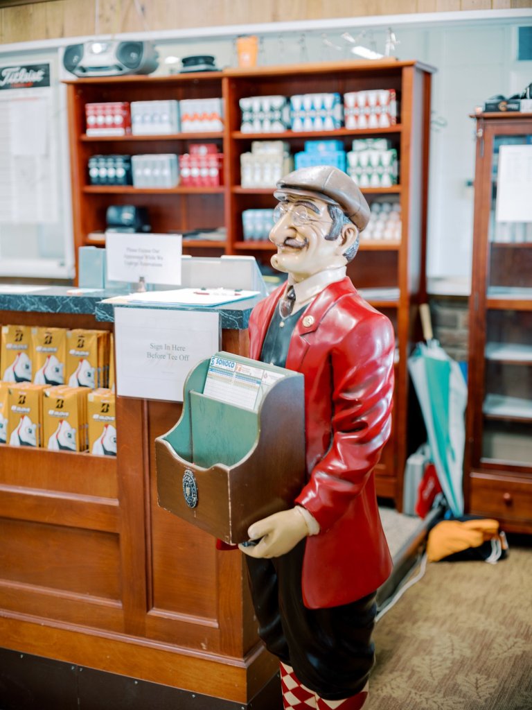 Friendly lawn statue holding box with scorecard